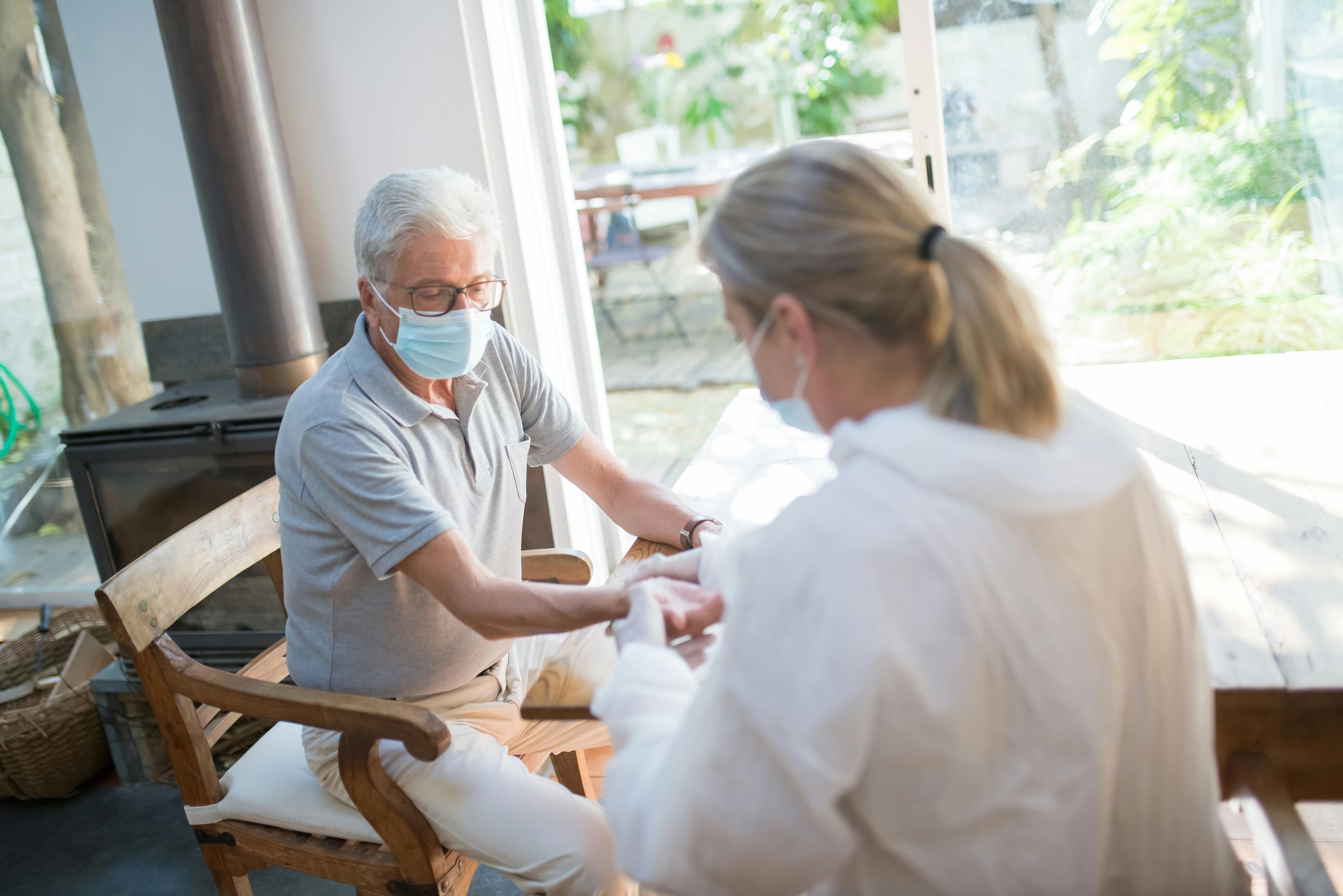 Care professional holding hands with a client at home